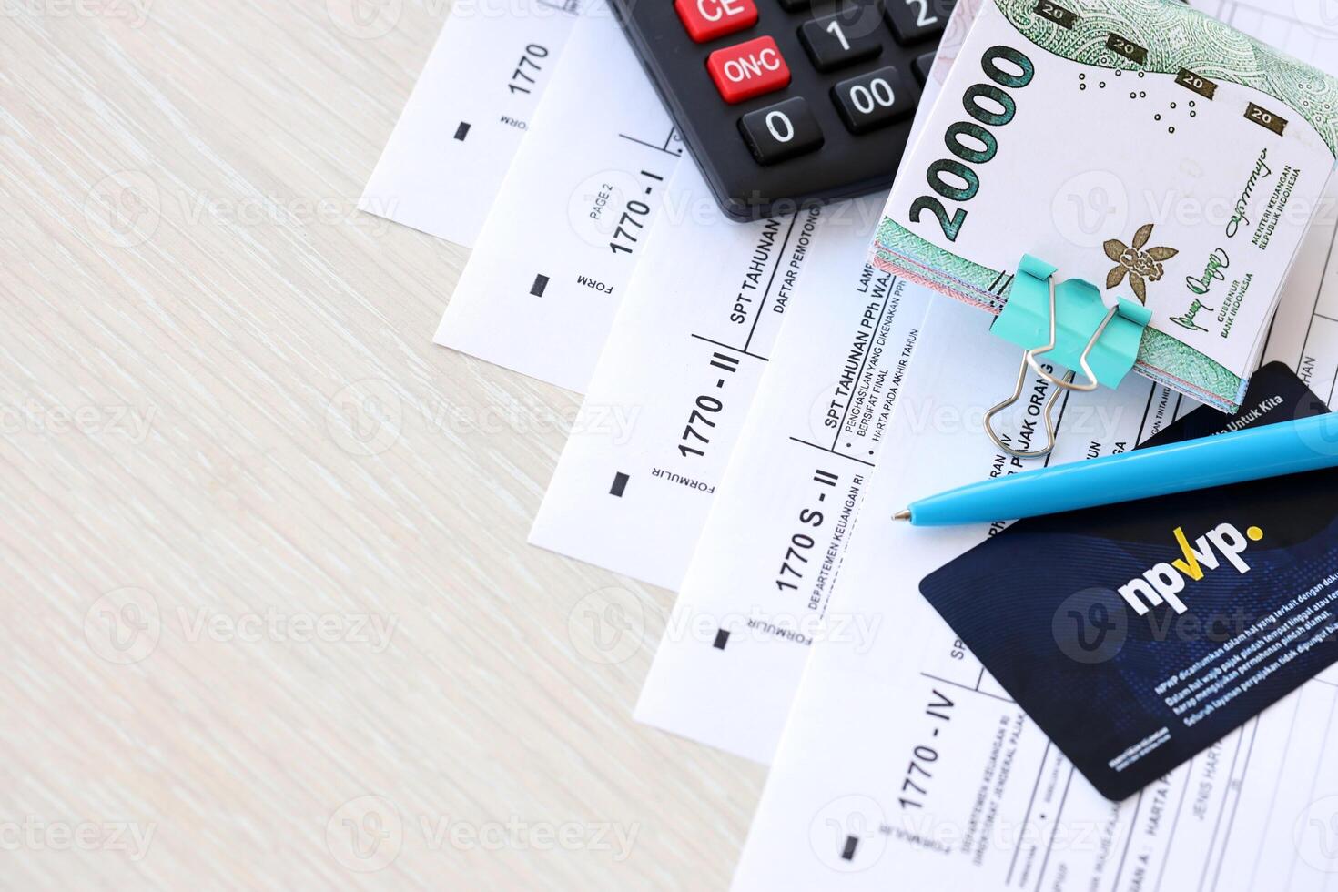 Annual Individual Income Tax Return forms with pen and indonesian rupiah bills photo