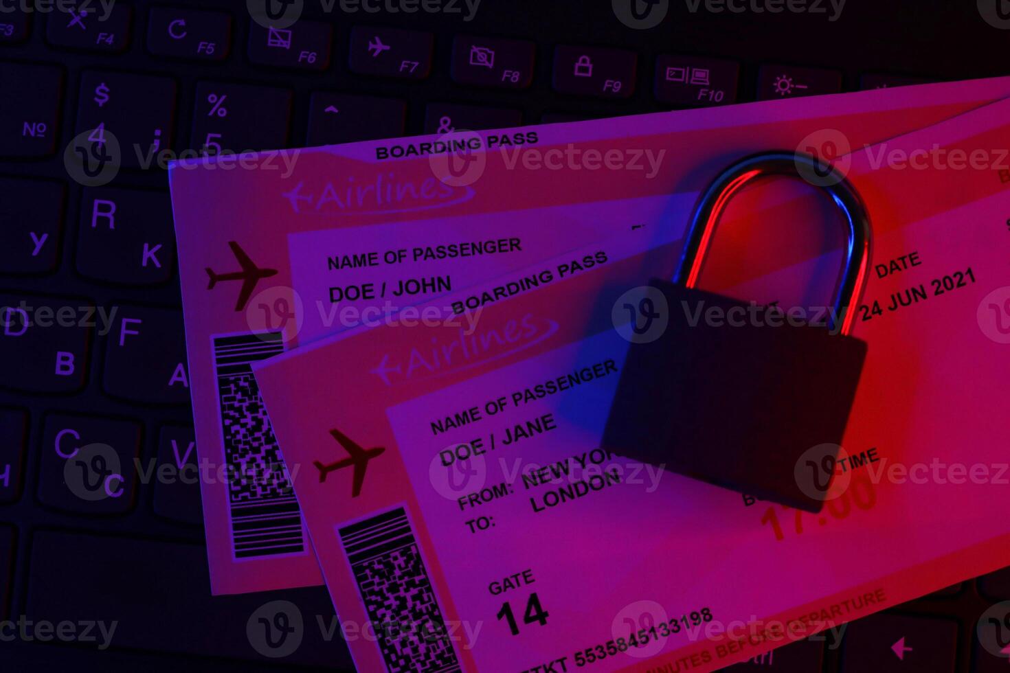 Fictional air tickets and small padlock on computer keyboard photo