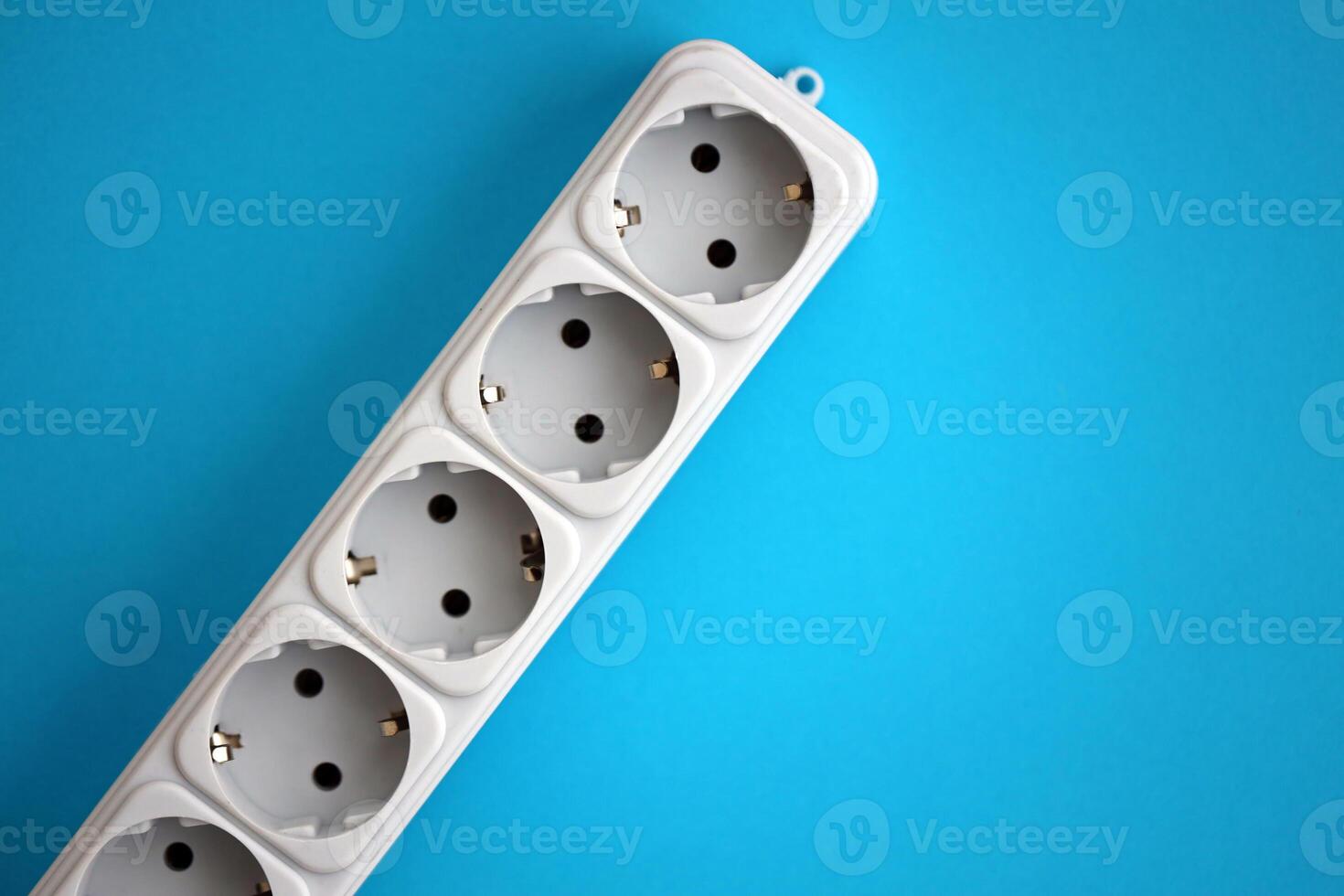 White electrical multi plug extender with european socket on bright blue background photo