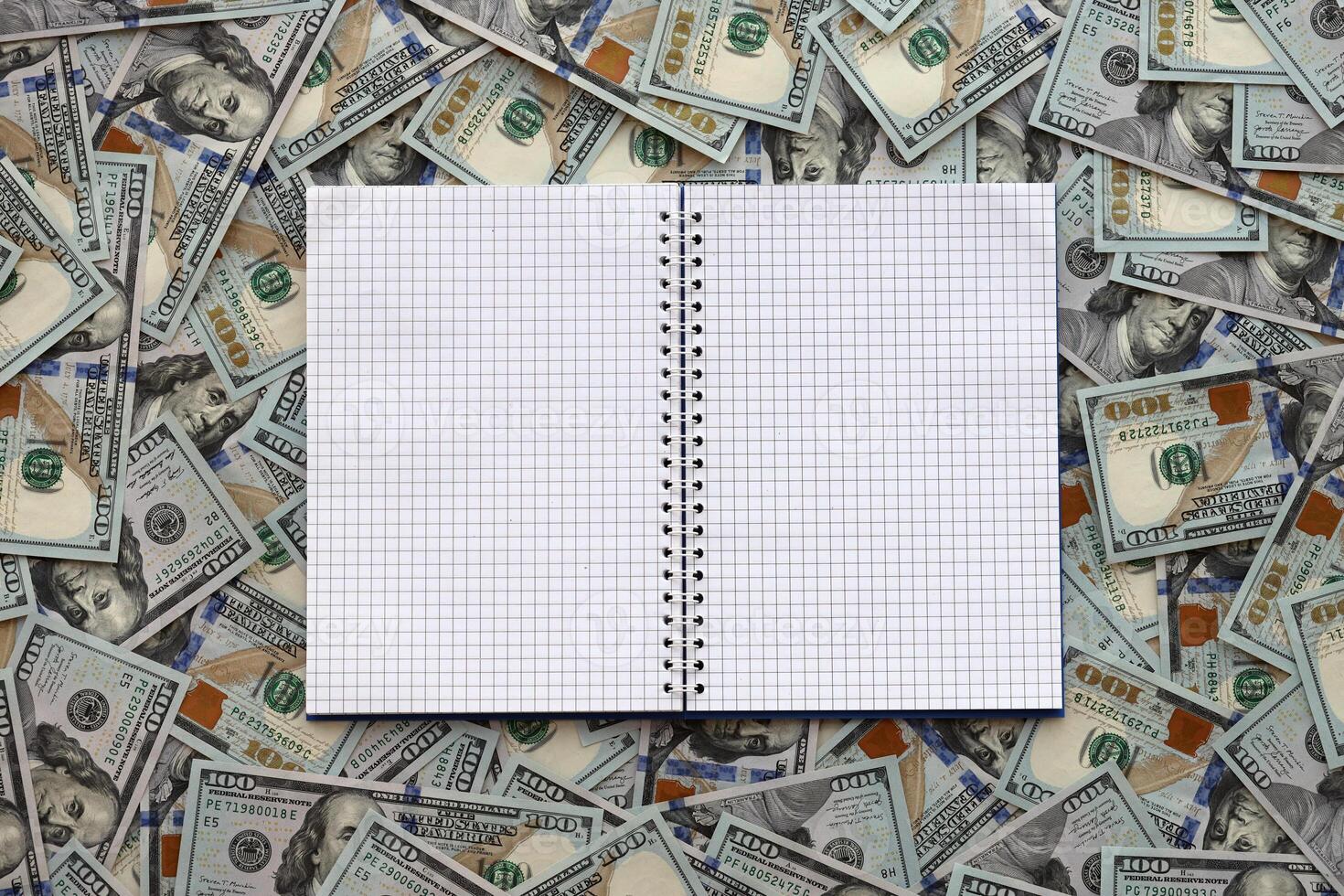 Office workplace table with blank notebook or notepad and many hundred dollar bills photo
