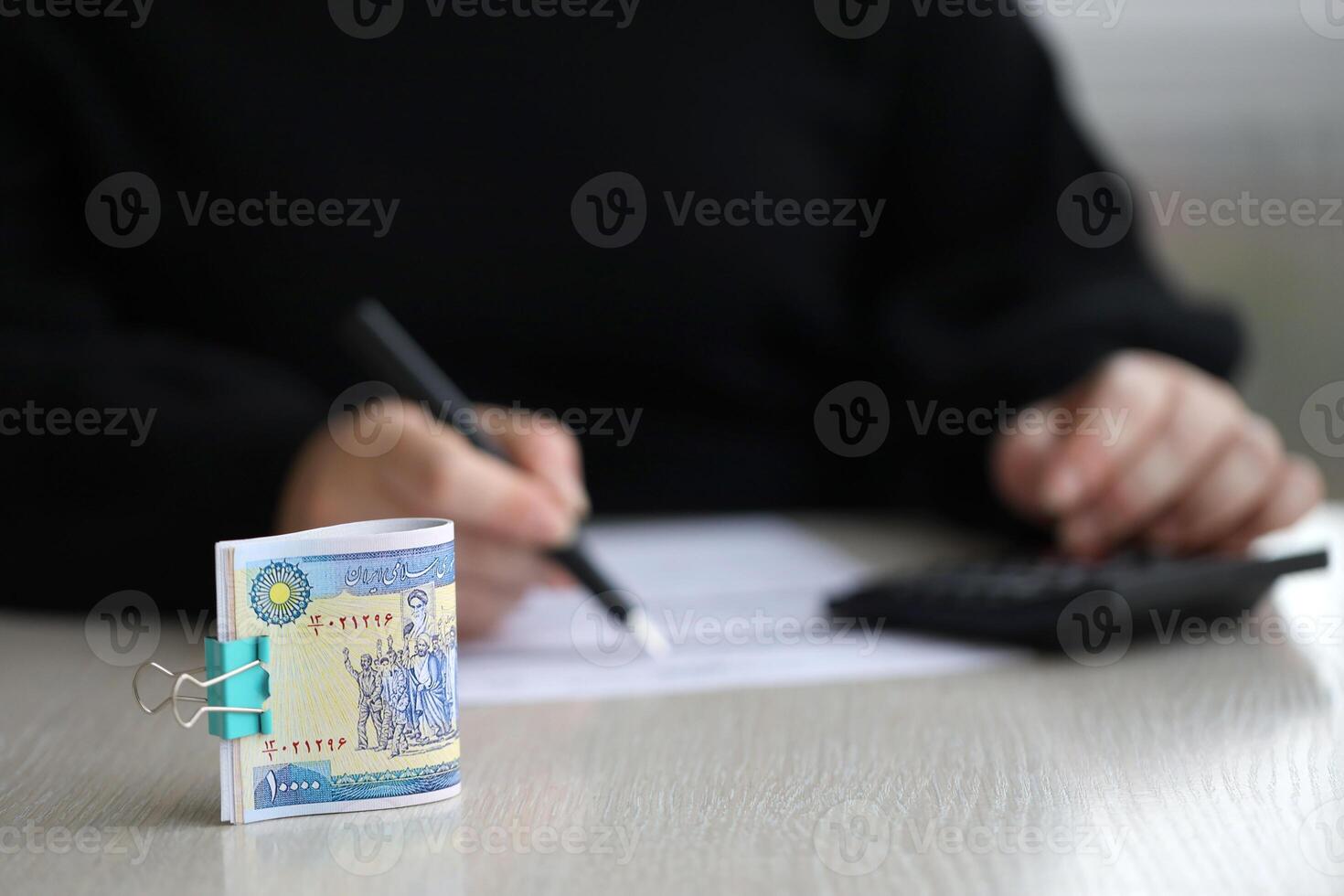Accountant start to fill Iranian tax form on office table. Taxation period and annual taxpayers routine photo