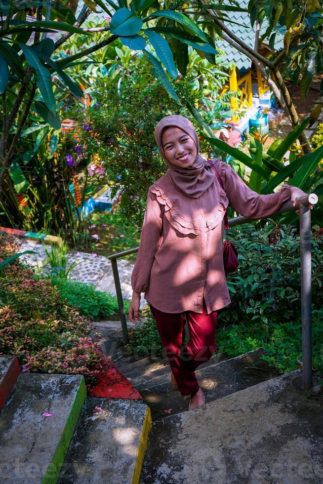 top view of a woman in a headscarf walking on the park steps facing the camera. photo