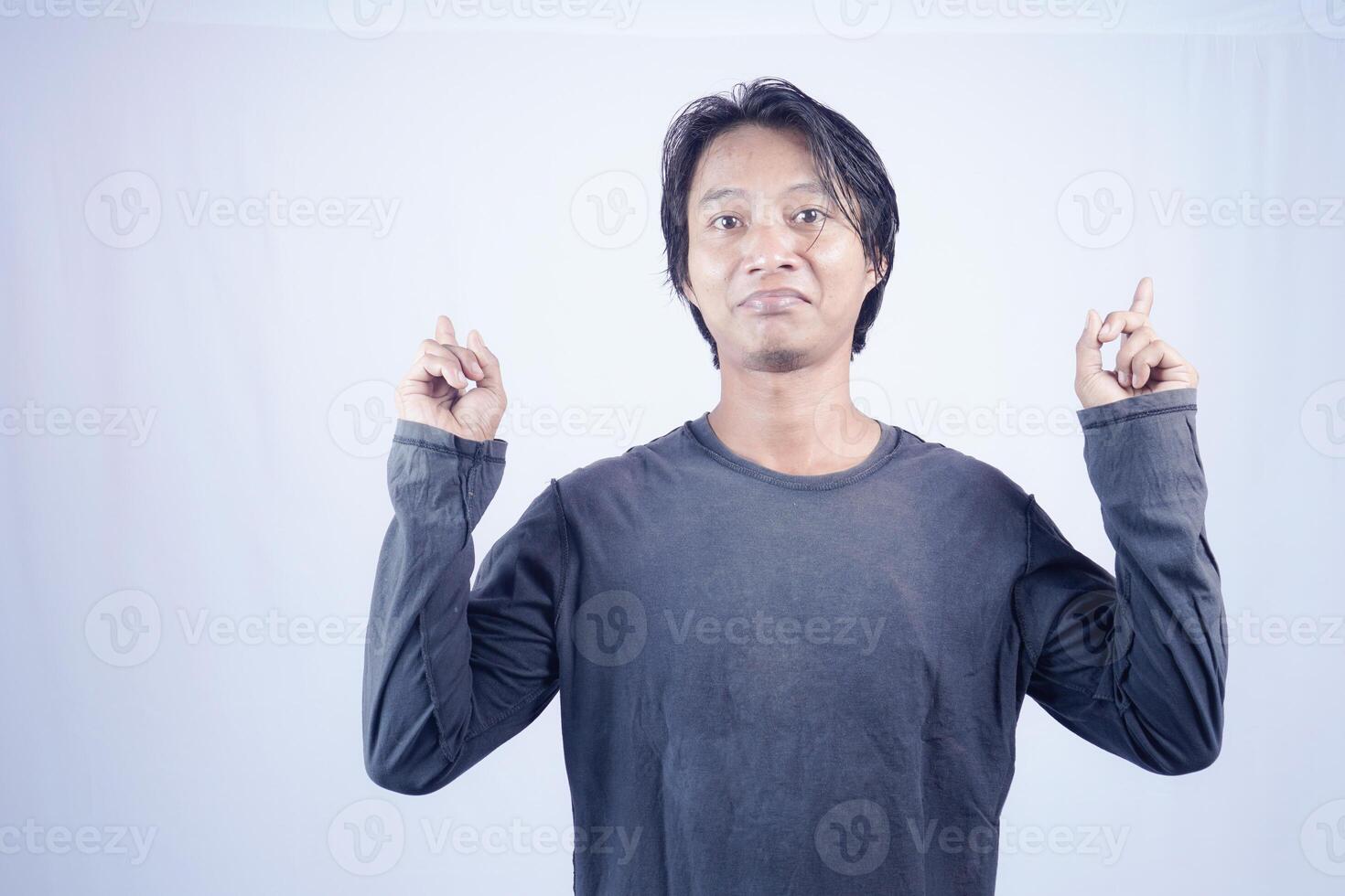 hermoso asiático hombre frente a el cámara es señalando a el Copiar espacio para publicidad en un aislado blanco antecedentes. foto