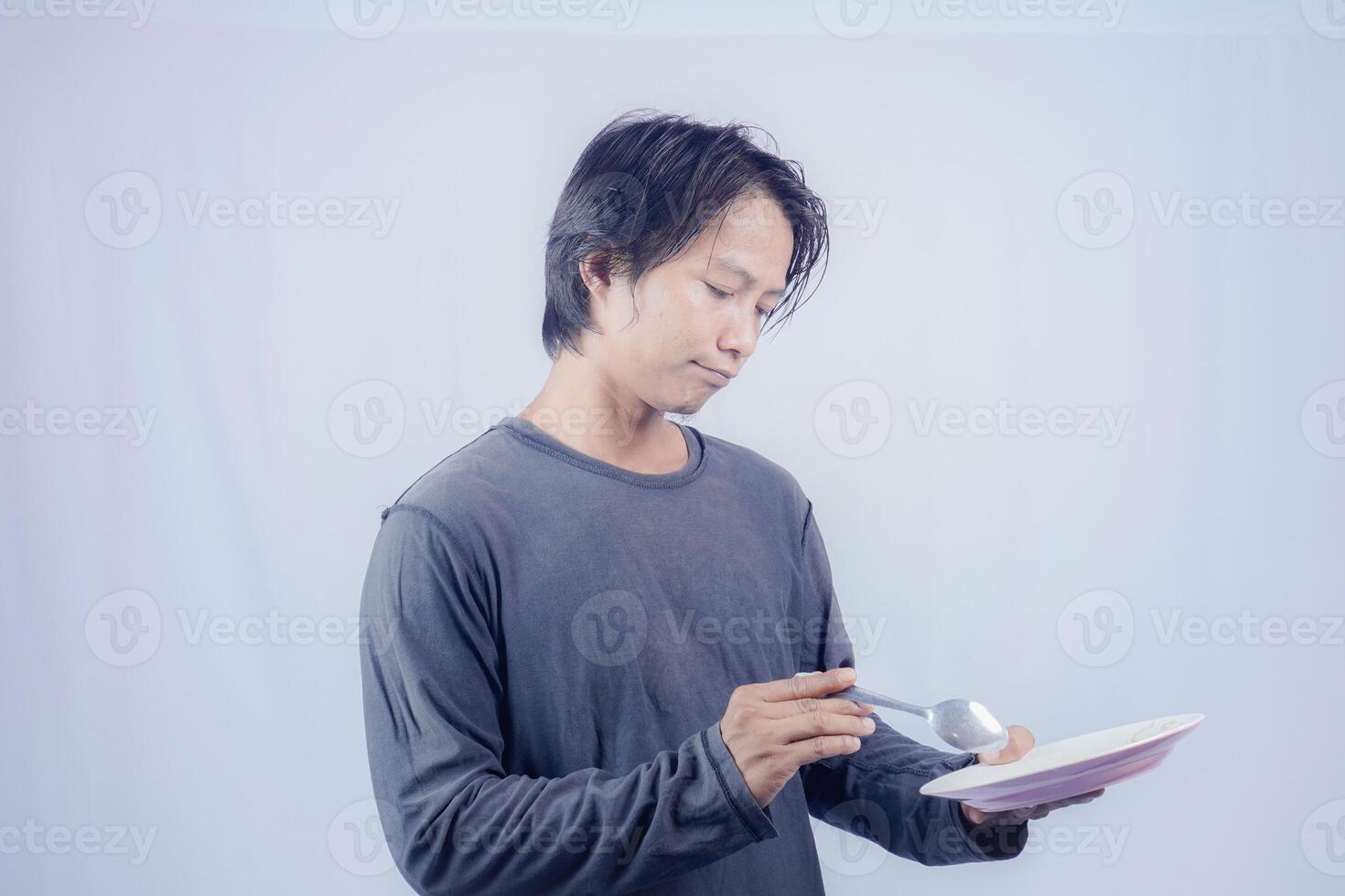 handsome asian man holding empty plate while thinking for serving food menu on isolated white background for advertising menu. menu presentation concept. photo