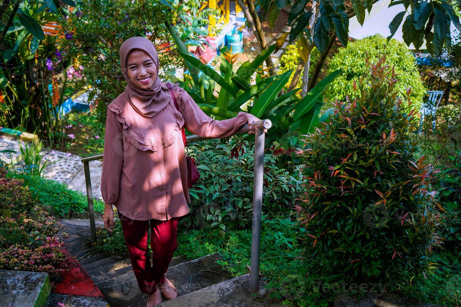 top view of a woman in a headscarf walking on the park steps facing the camera. photo