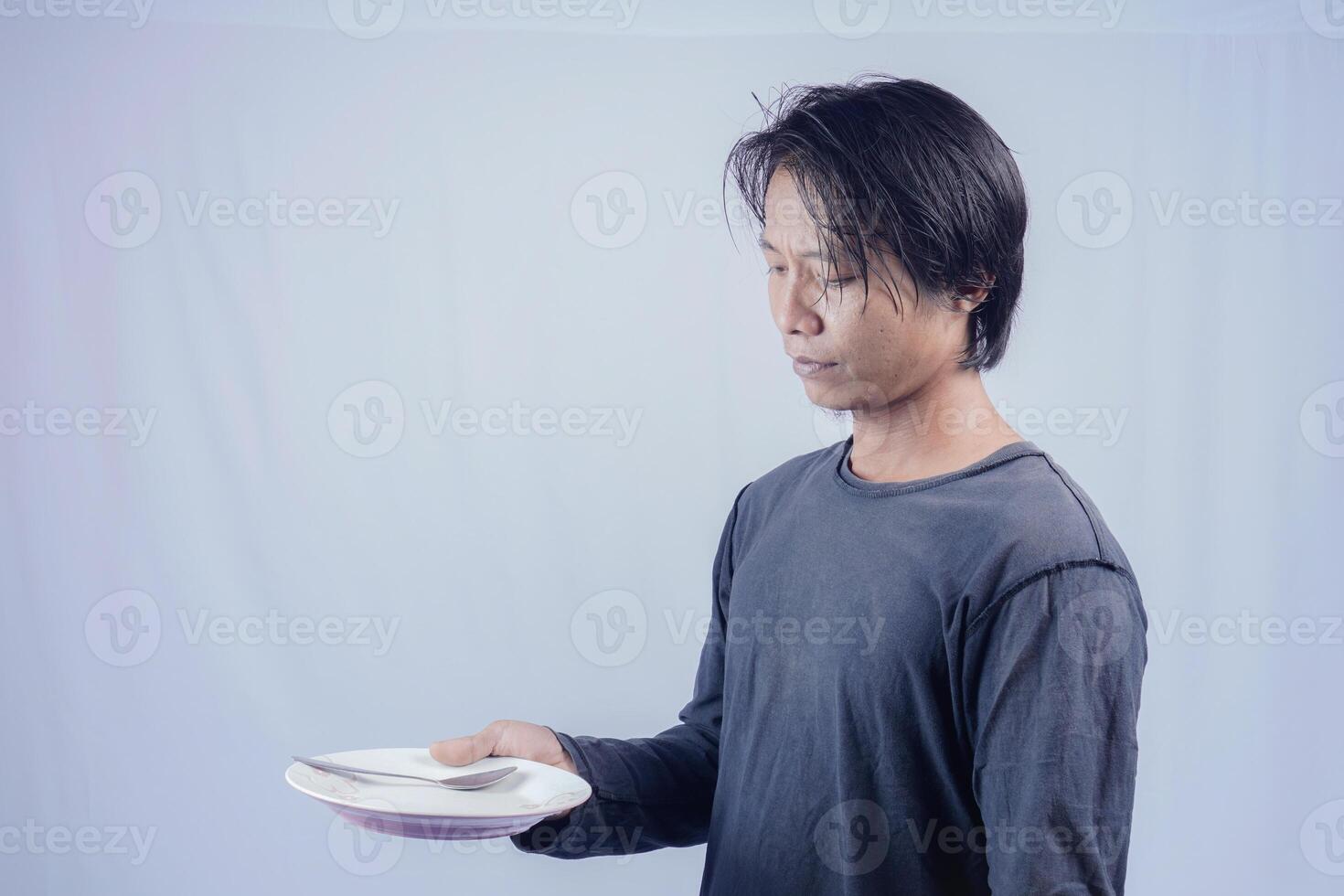 hermoso asiático hombre participación vacío plato mientras pensando para servicio comida menú en aislado blanco antecedentes para publicidad menú. menú presentación concepto. foto