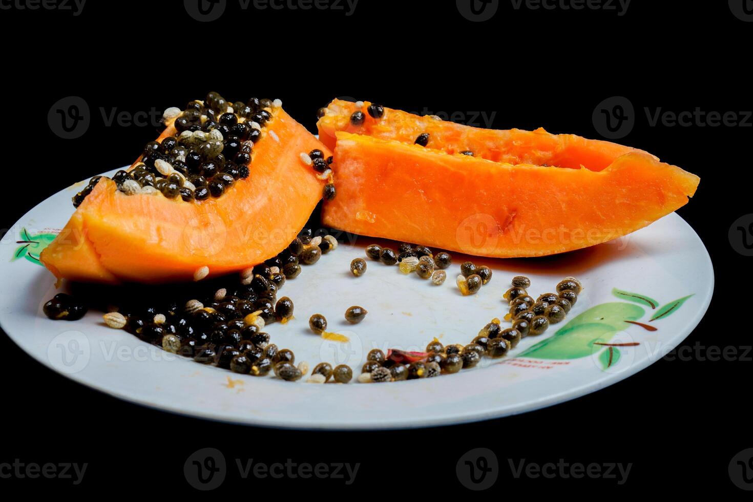 close up view of papaya fruit isolated on plate on black background. photo