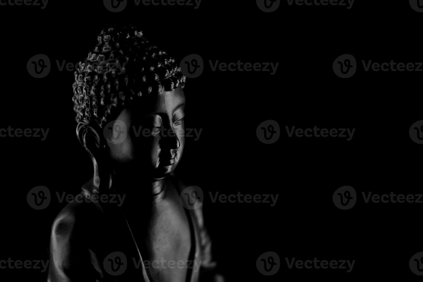 Buddha Purnima and Vesak day concept, Grey Buddha statue with low key light against deep black background photo