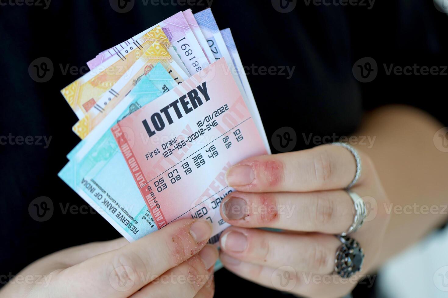 Woman hands with indian rupees bills and lottery ticket. Concept of gambling and winning money in indian lottery photo