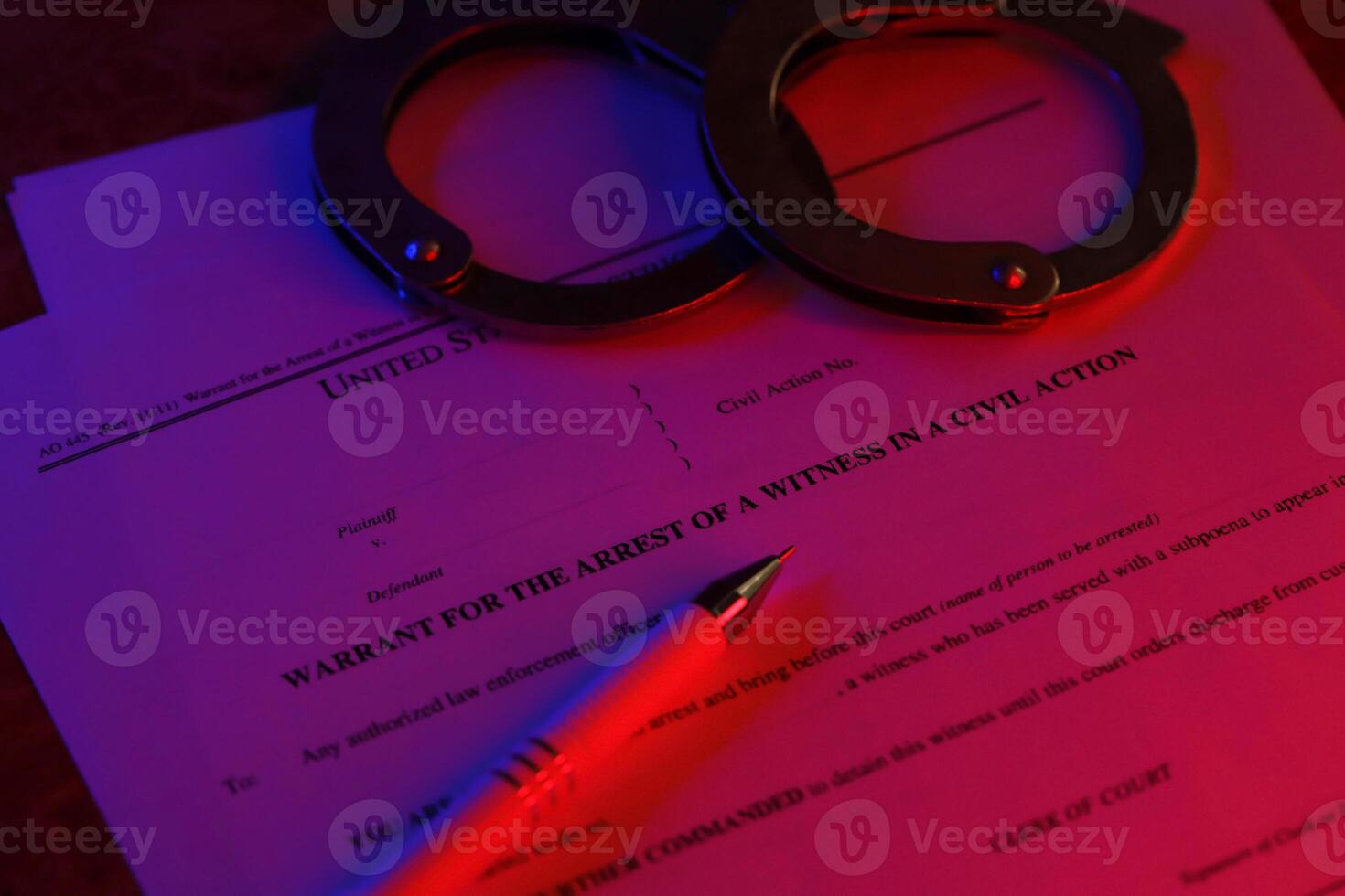 District court warrant for the arrest of a witness in a civil action papers with handcuffs and blue pen on United States flag. Permission to witness photo