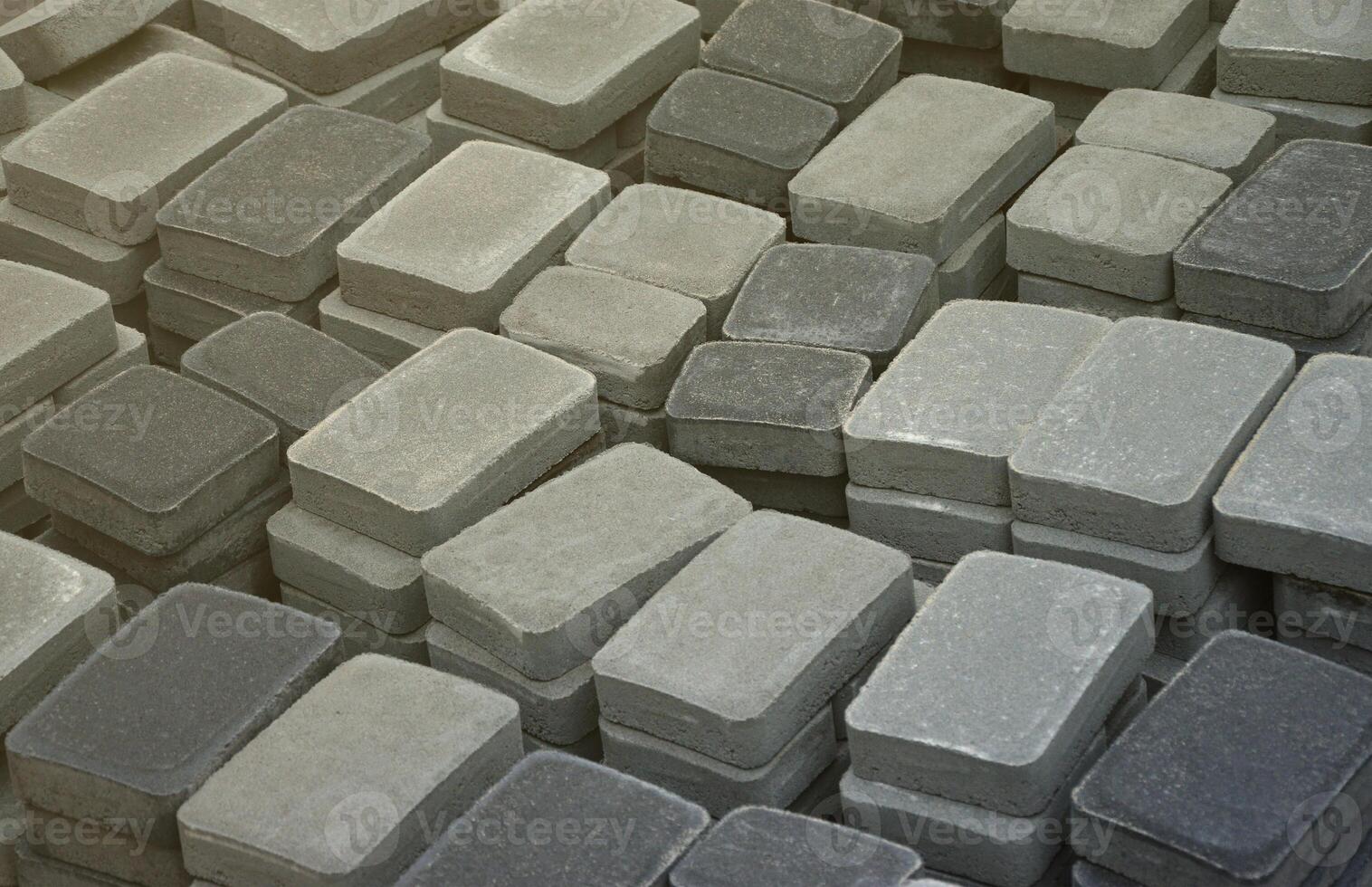 Pile of gray and dark grey walkway slab lying down outdoor. Material for Paving Slabs by mosaic close-up. Cobblestone production photo