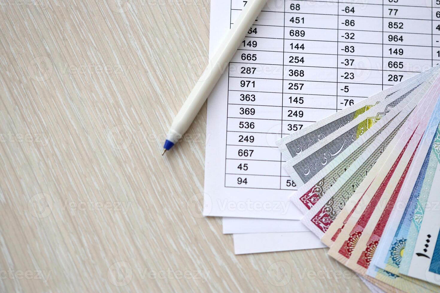Iranian business calculations on table with iranian money and pen photo