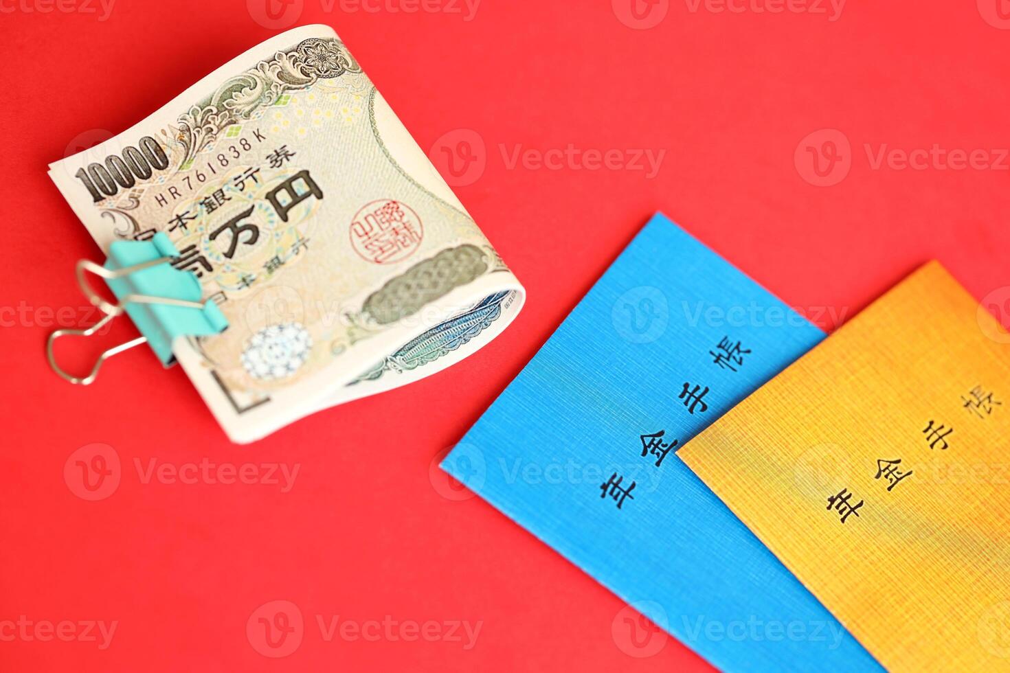 Japanese pension insurance booklets on table with yen money bills. Blue and orange books photo