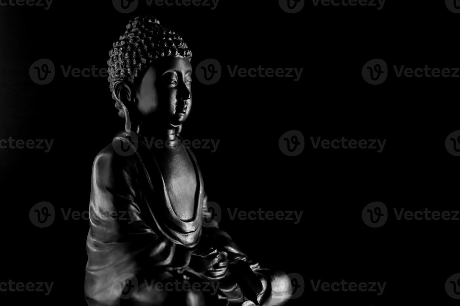 Buddha Purnima and Vesak day concept, Grey Buddha statue with low key light against deep black background photo