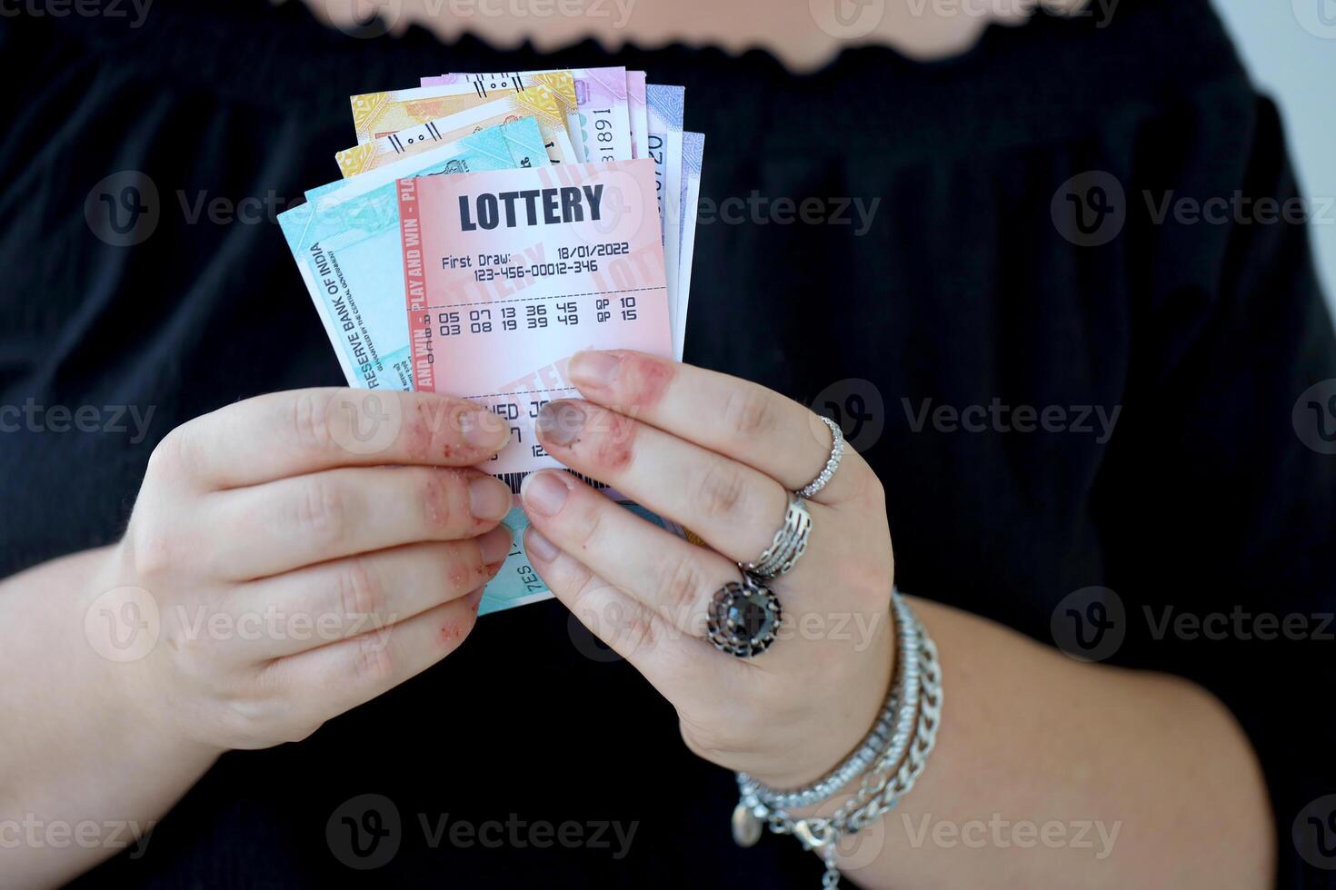 Woman hands with indian rupees bills and lottery ticket. Concept of gambling and winning money in indian lottery photo