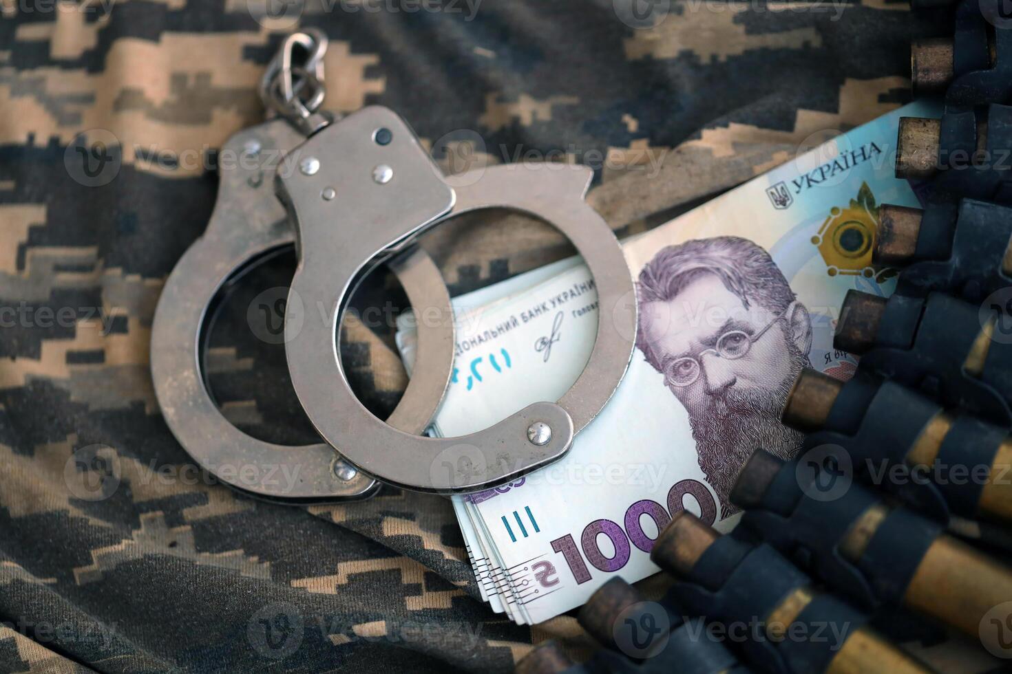 Ukrainian army machine gun belt shells and handcuffs on military uniform. Concept of bribery and war crimes photo