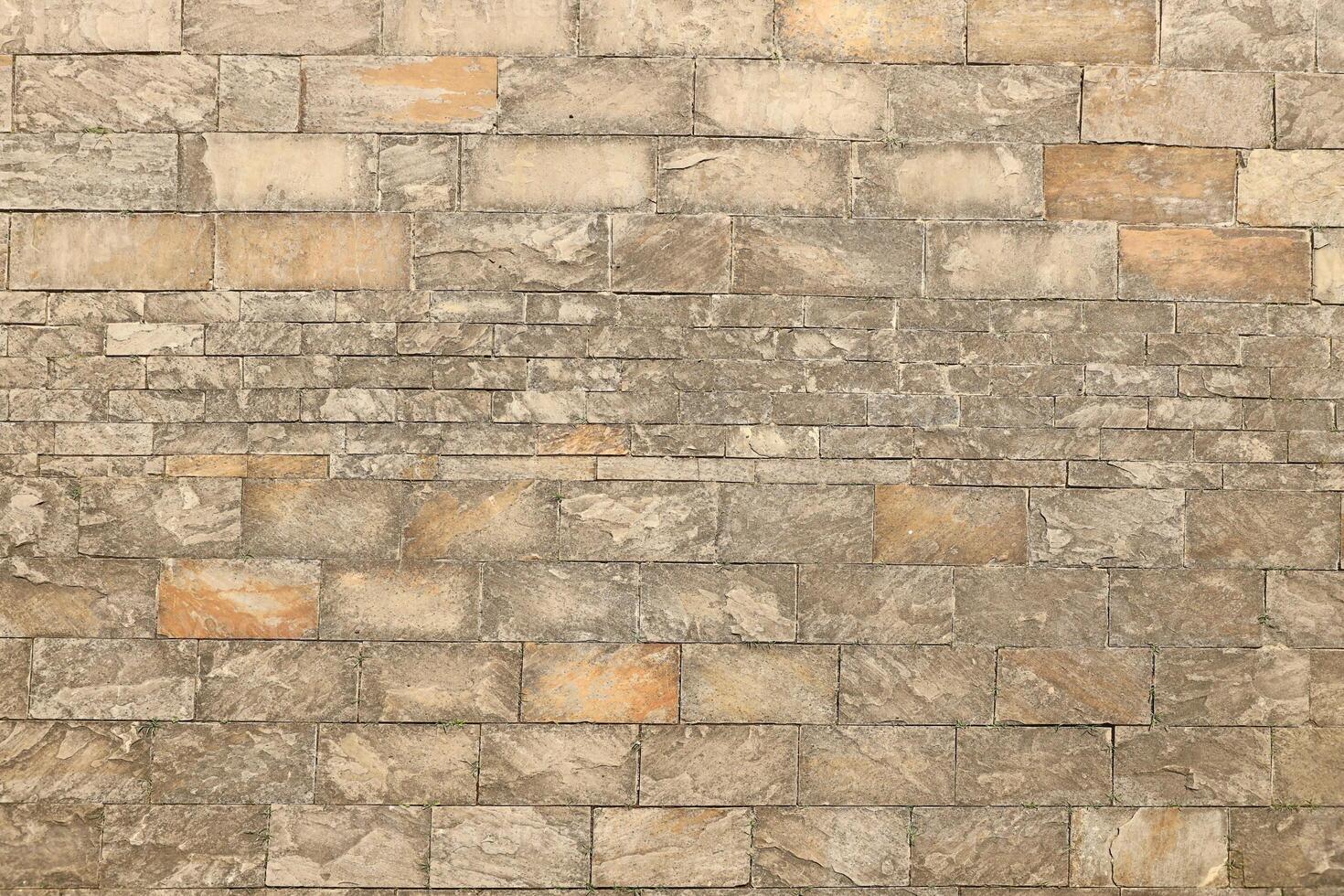 Very old brick stone wall of castle or fortress of 18th century. Full frame wall with obsolete dirty and cracked bricks photo
