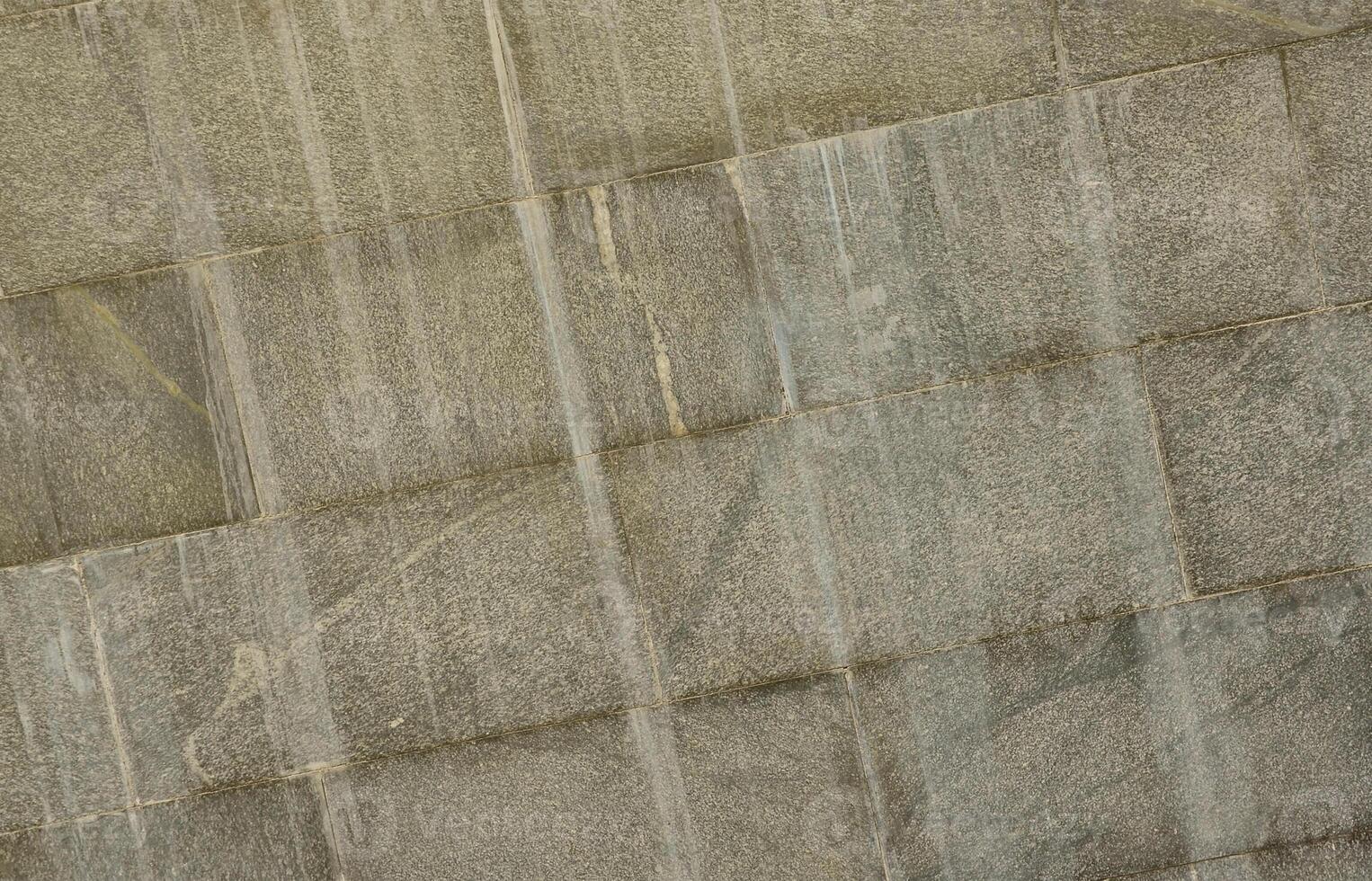 The texture of a wall of large granite tiles that are covered with white streaks when exposed to dampness photo