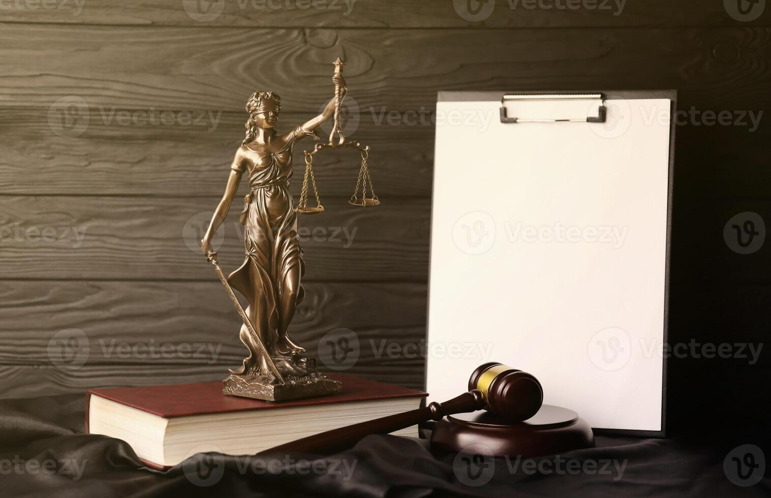 Lady justice or justitia the Roman goddess of Justice. Statue on brown book with judge gavel on blank paper background with copyspace. Concept of judicial trial, courtroom process and lawyers work photo