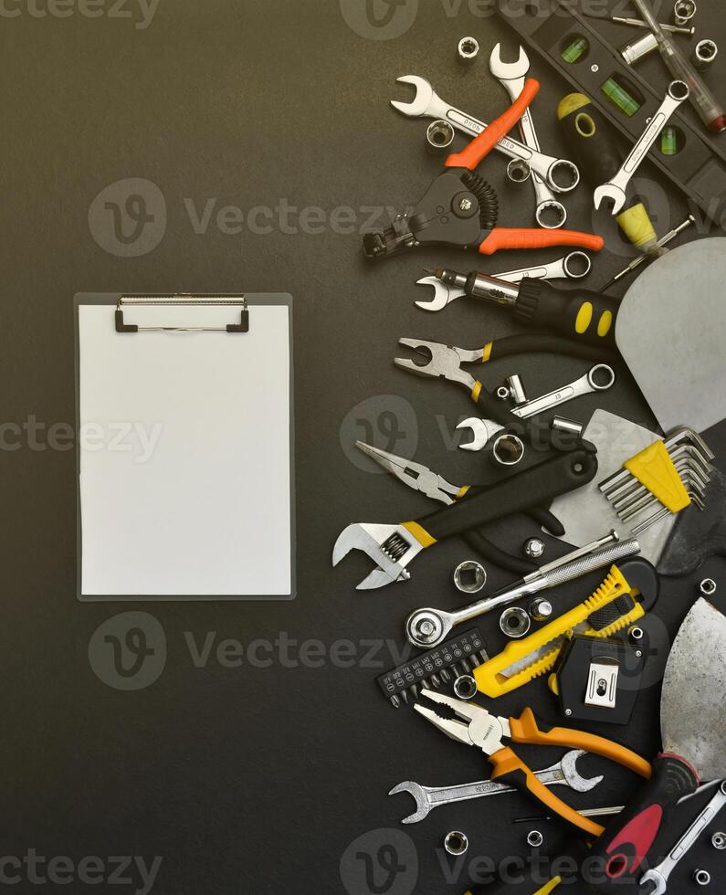 Handyman tool kit on black wooden table. Many wrenches and screwdrivers, pilers and other tools for any types of repair or construction works. Repairman tools photo