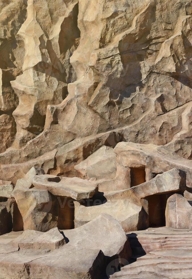 Light coarse natural rock stone background. Mining cliff rough front surface. Big limestone stack backdrop. Heavy grunge damaged granite block texture photo