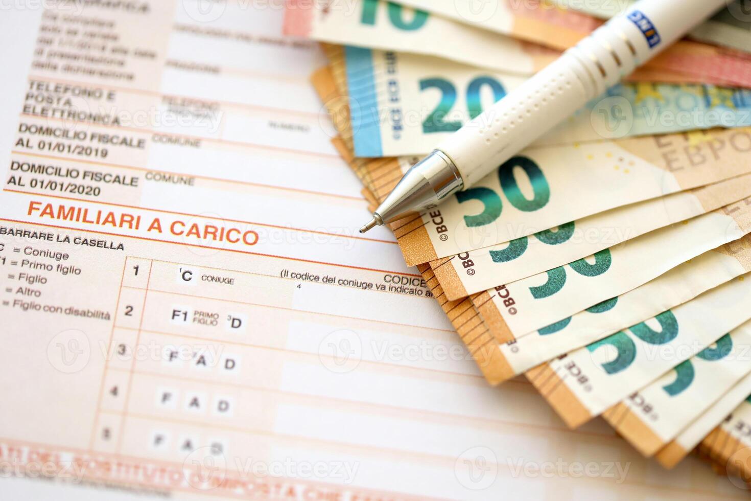 Filling italian tax form process with pen and euro money bills close up. Tax paying period photo