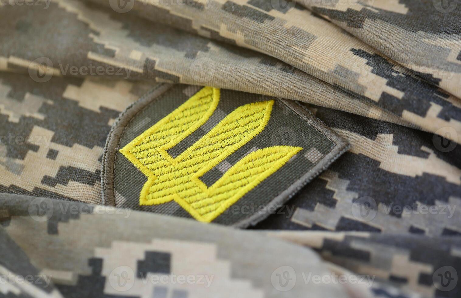 Symbol of Ukrainian army on the camouflage uniform of a Ukrainian soldier. The concept of war in Ukraine, patriotism and protecting your country from occupiers photo