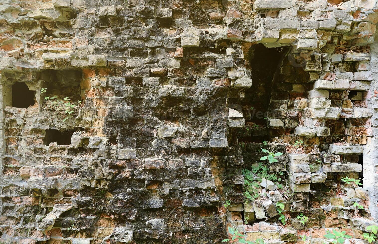 Very old brick stone wall of castle or fortress of 18th century. Full frame wall with obsolete dirty and cracked bricks photo