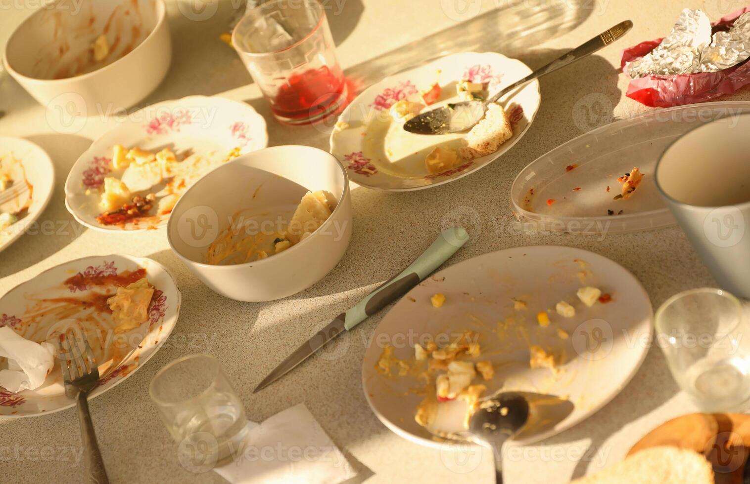 Empty dirty plates with spoons and forks on the table after meal. Banquet ending concept. Unwashed dishes photo