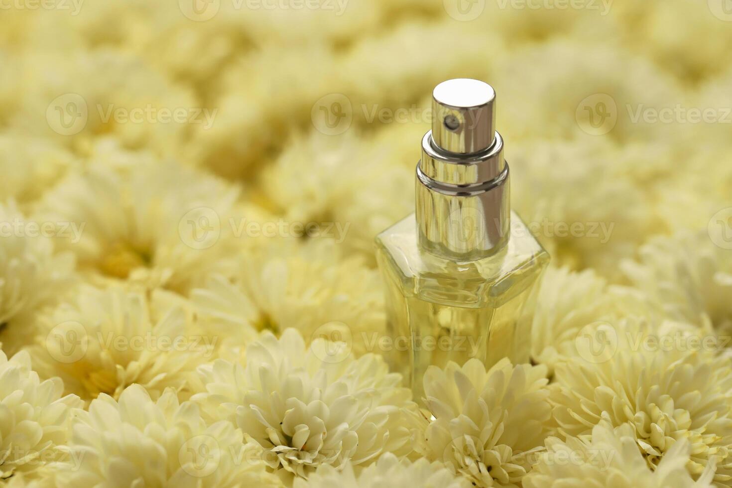 Women fragrance perfume bottle with flowers background close up. Unnamed blank sprayer bottle of perfume photo