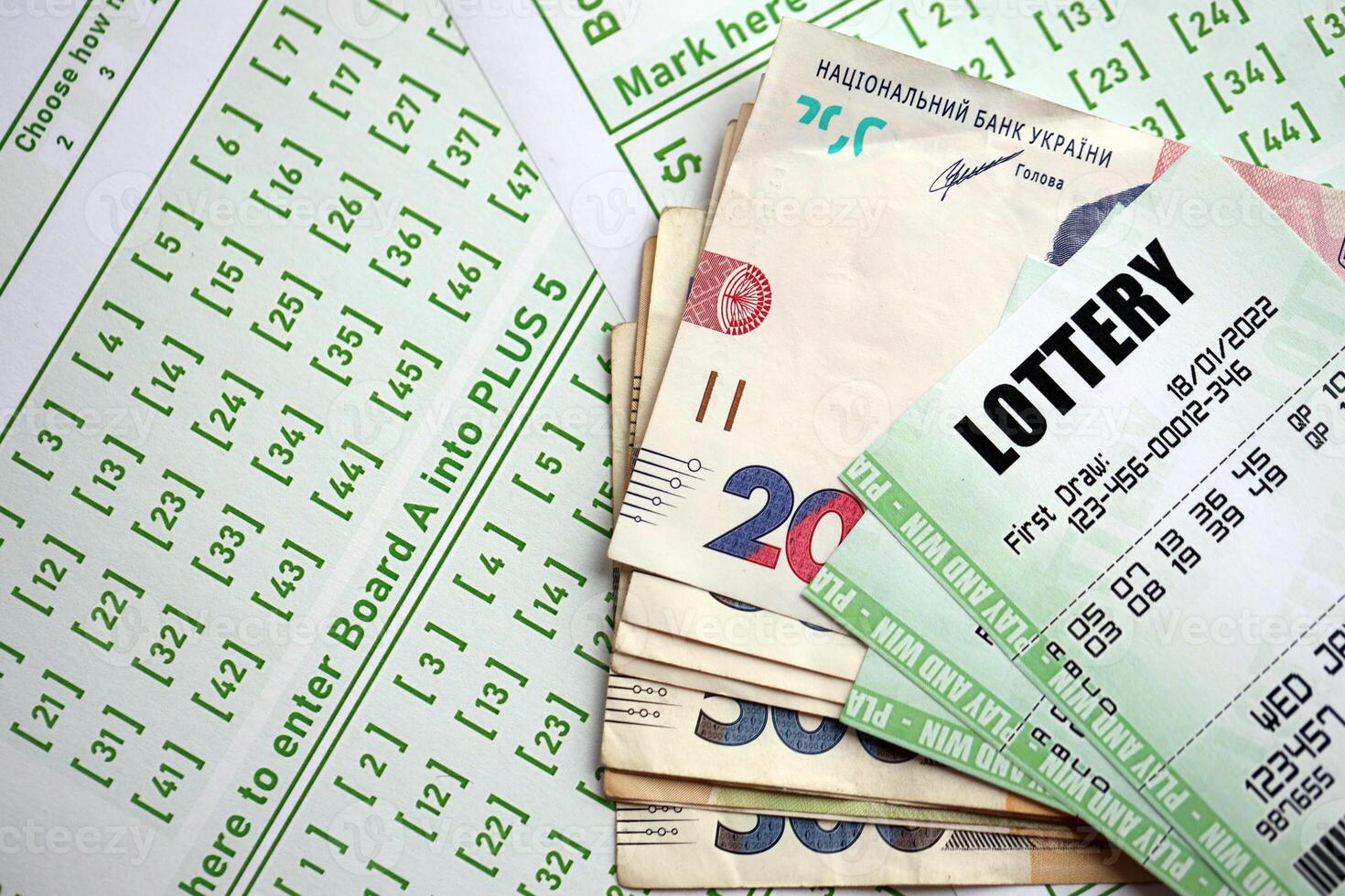 Green lottery tickets and ukrainian money bills on blank with numbers for playing lottery photo