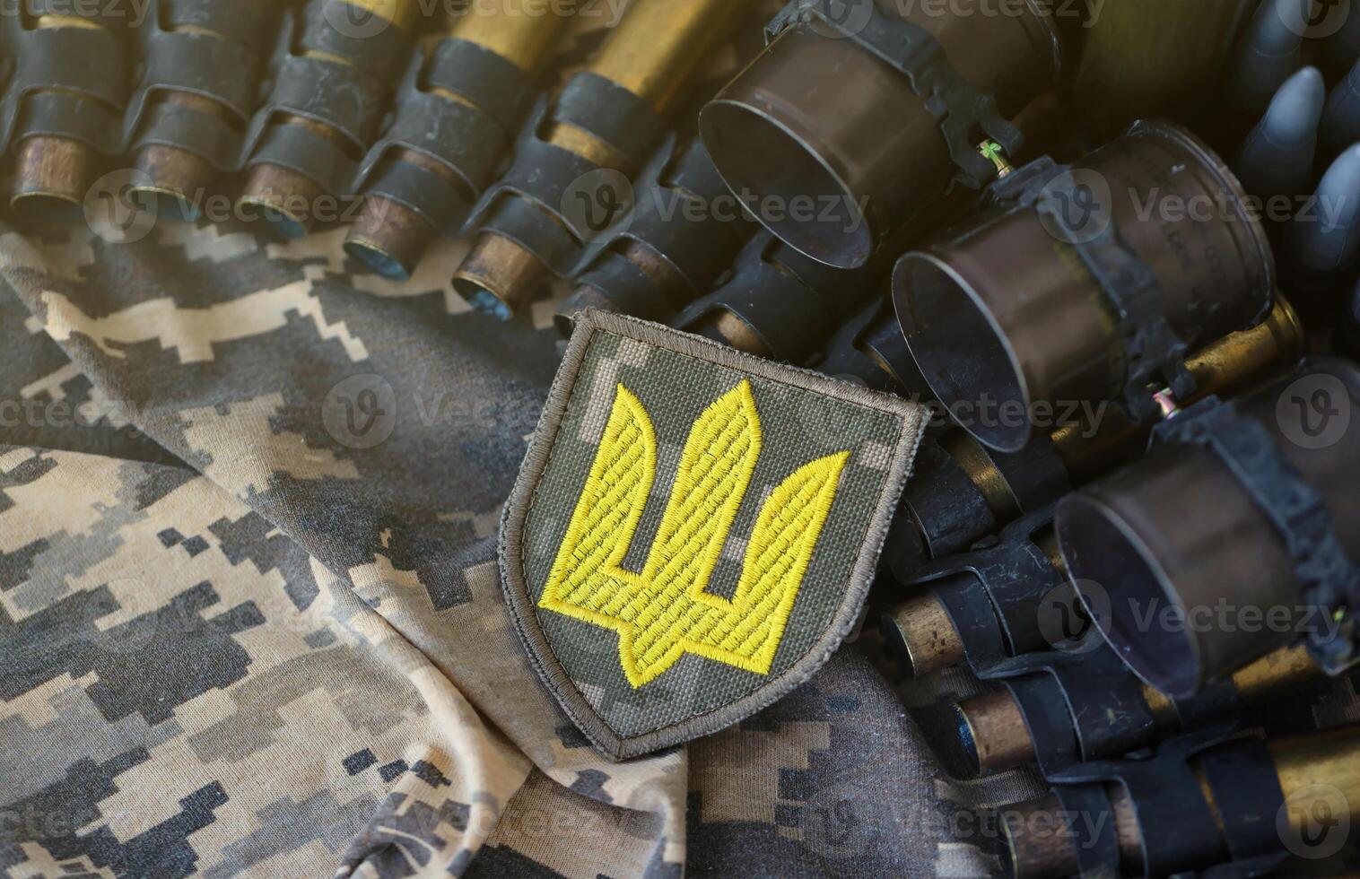 Ukrainian army symbol on machine gun belt lies on ukrainian pixeled military camouflage photo