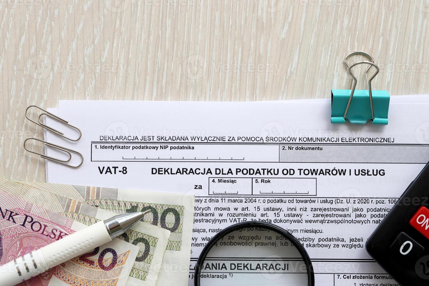 Declaration for tax on goods and services VAT-8 form on accountant table with pen and polish zloty money bills photo