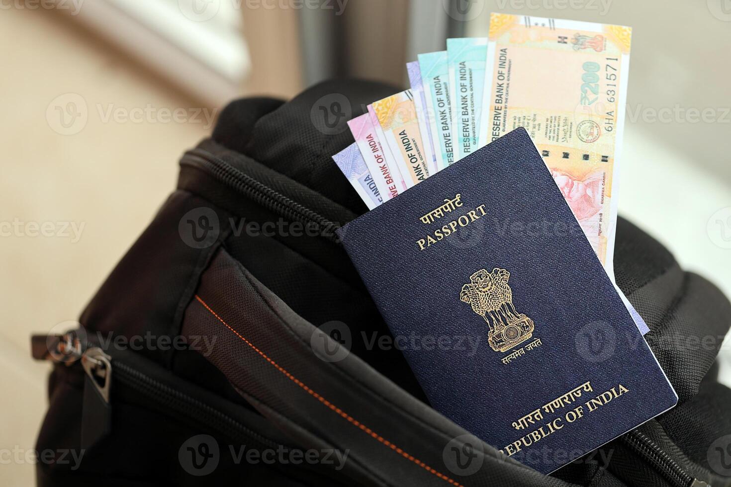 Blue Indian passport with money and airline tickets on touristic backpack photo