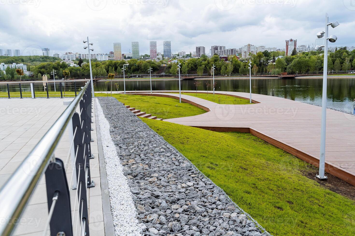 Metal railings in the city park, the construction of a recreation area for city dwellers, wooden roads made of boards, a beautiful park by the lake, a pond for relaxation. photo