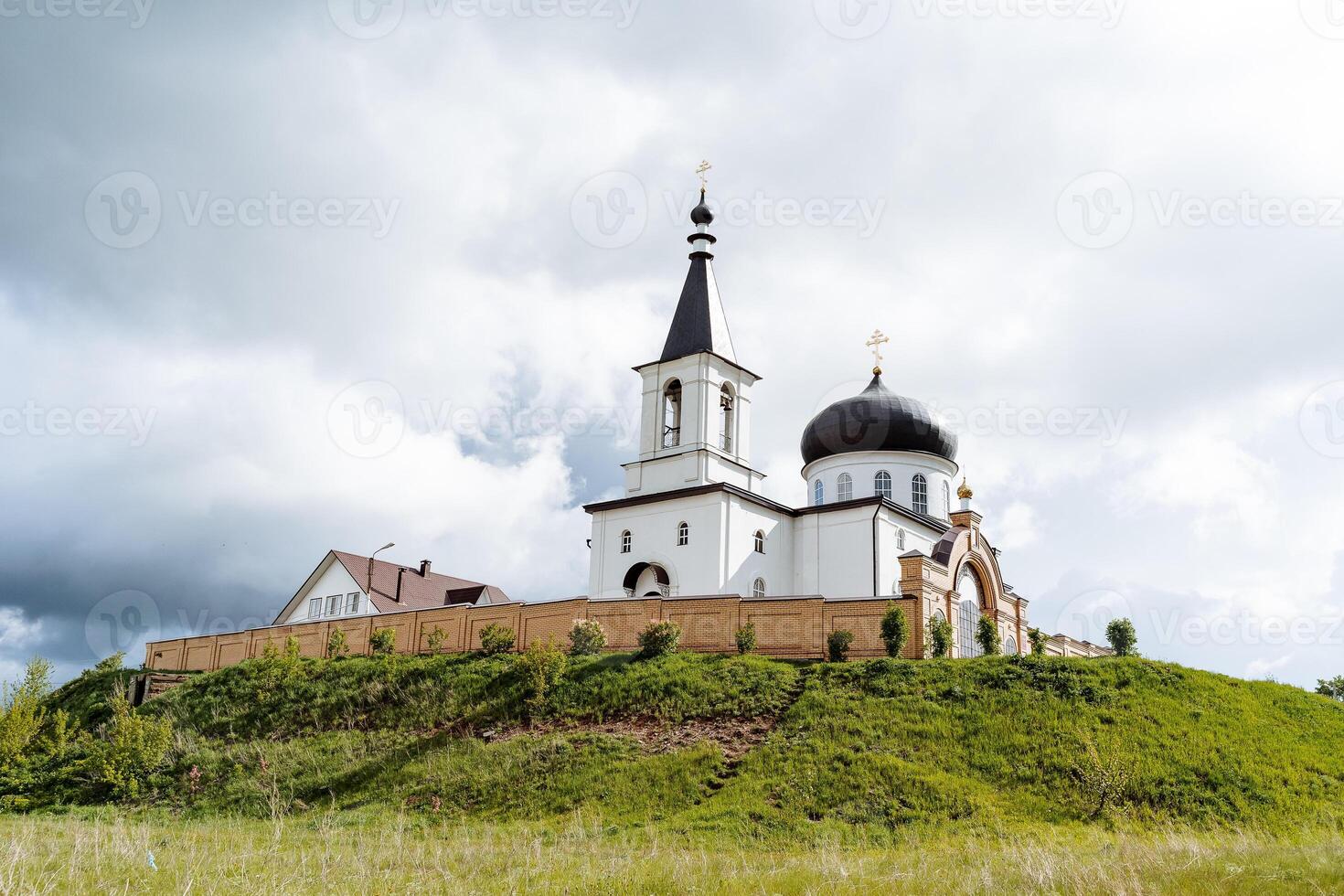 Panorama of the church church against the background of a cloudy sky, an Orthodox monastery stands on a mountain, an old Russian fortress, a Christian monastery. photo