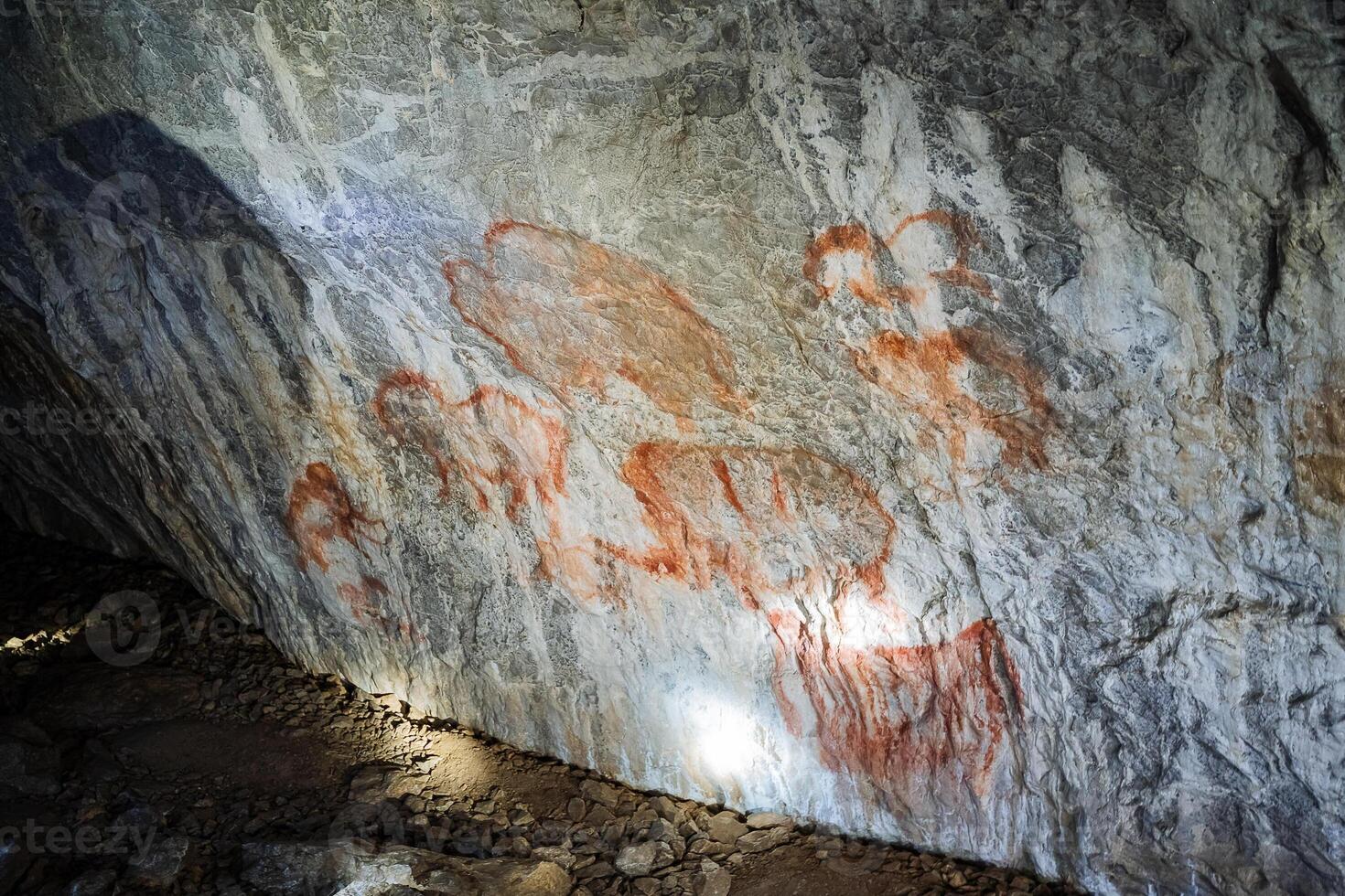 Rock paintings in the cave, ancient people painted on the walls of an underground dwelling, pictures of a caveman, a find of the century. photo