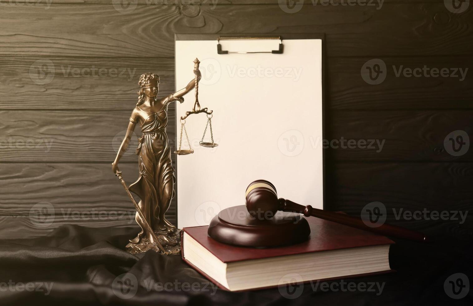 Lady justice or justitia the Roman goddess of Justice. Statue on brown book with judge gavel on blank paper background with copyspace. Concept of judicial trial, courtroom process and lawyers work photo