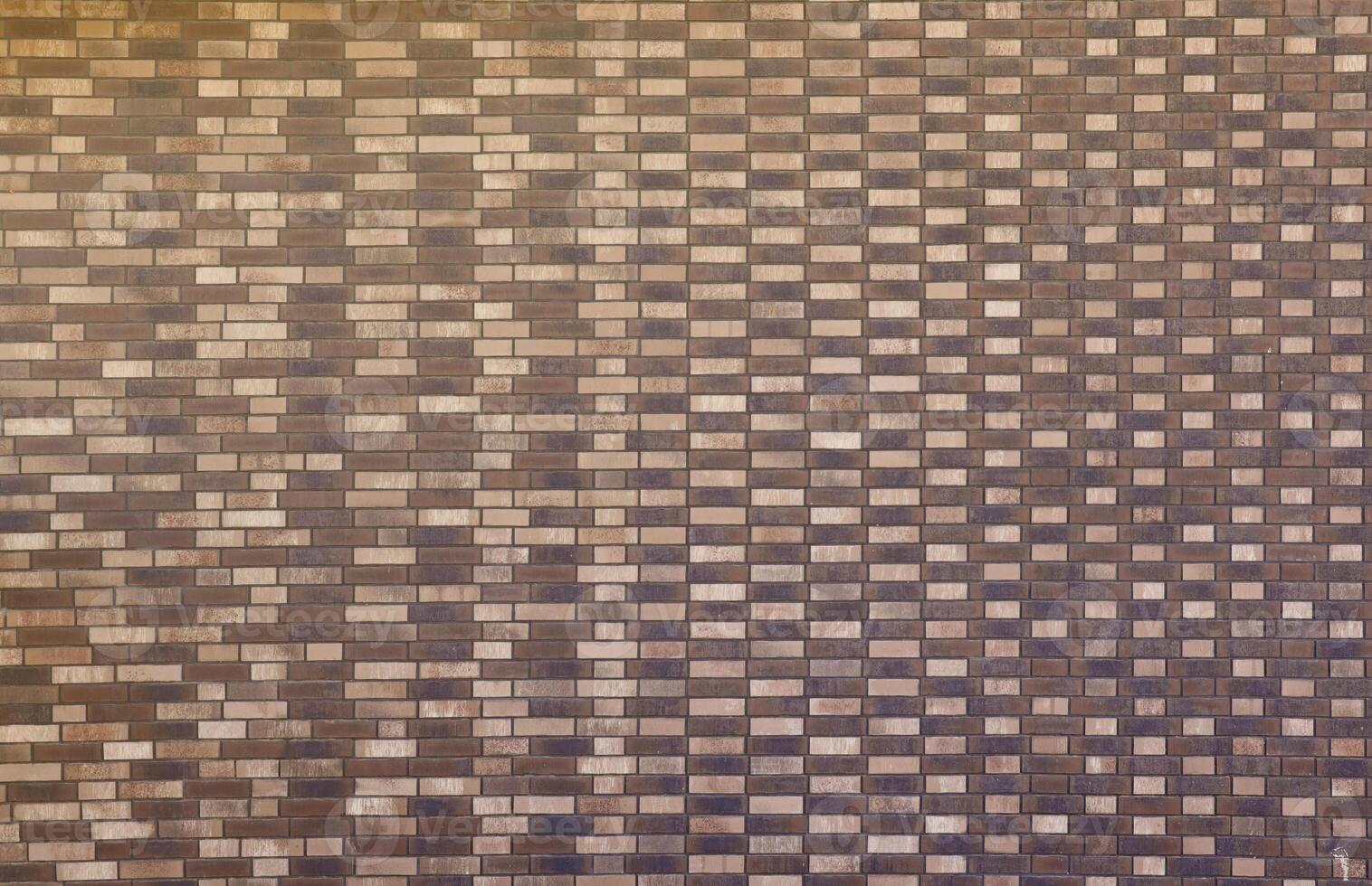 Dark brick wall pattern with chaotic masonry order. Background texture or resource for 3d texturing. Many bricks in big modern stone wall photo