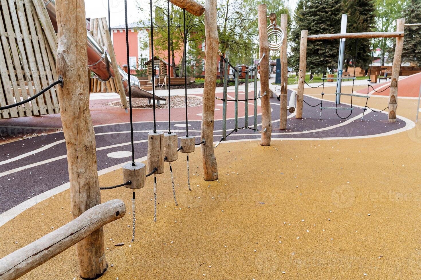 The children's sports complex is made of logs, a wooden playground in the city park, obstacles for children, the development of dexterity and coordination, safe playground coverage. photo