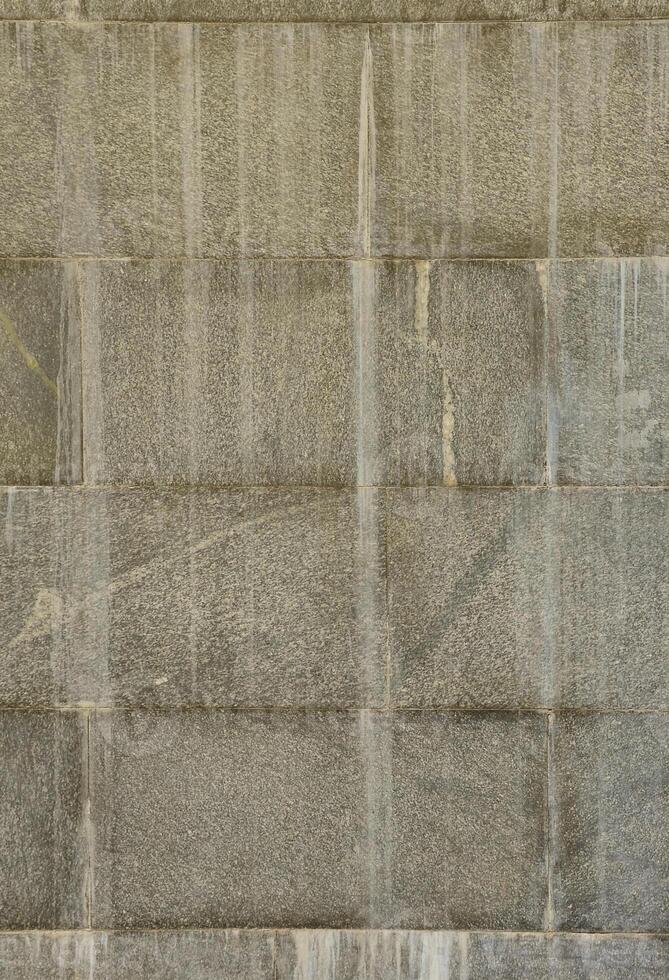 The texture of a wall of large granite tiles that are covered with white streaks when exposed to dampness photo