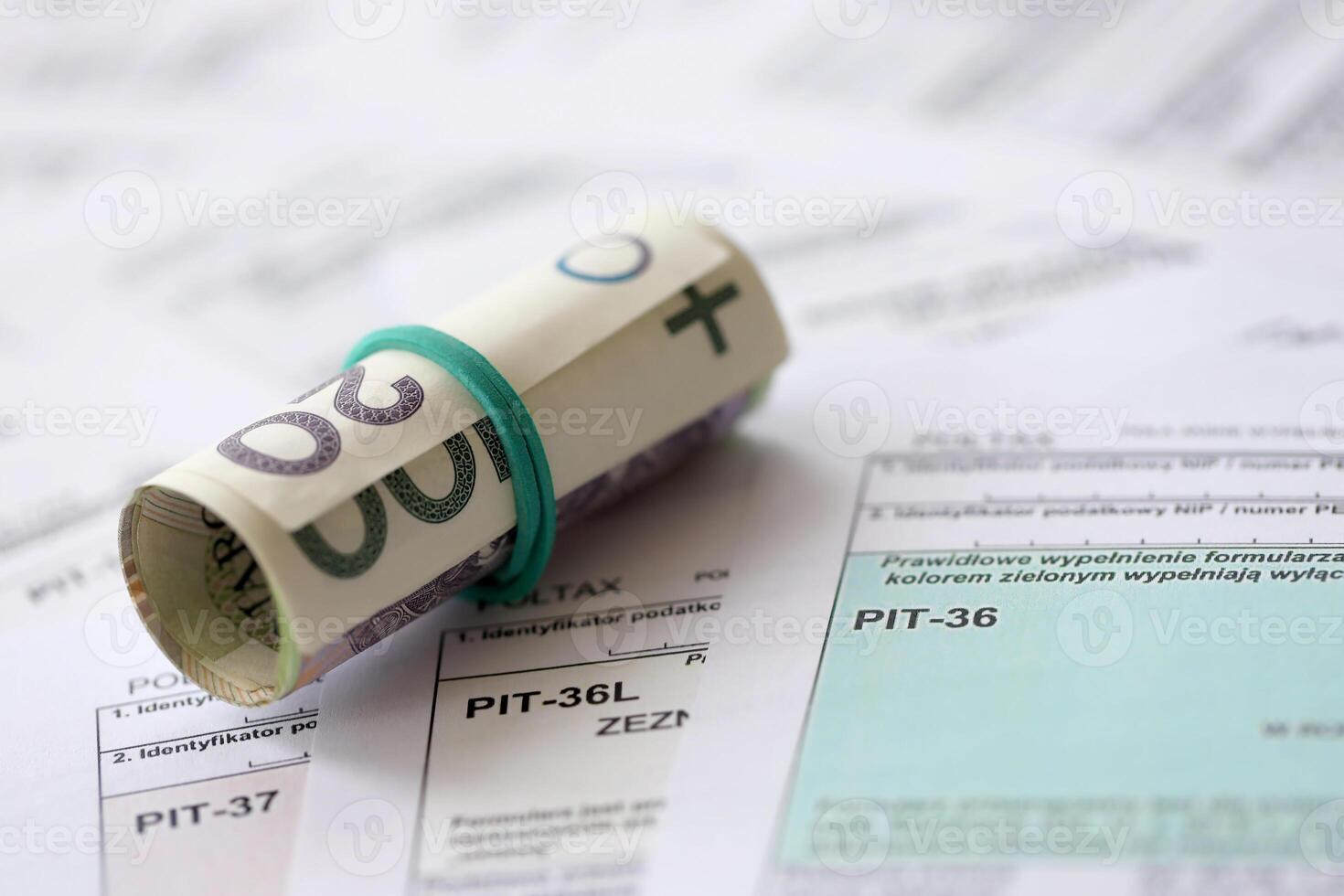 Polish zloty money on big amount of polish tax forms close up. Accounting, bureaucracy and taxpayers routine photo