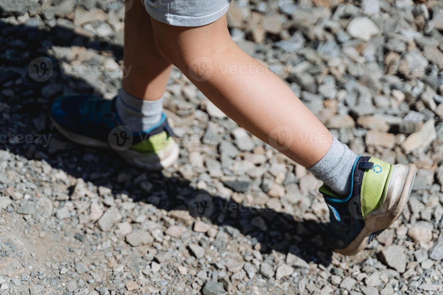 baby legs top view, boy walking on the road, foot in sneaker, short step, baby legs, minimalism of the human body, shadow from the child photo