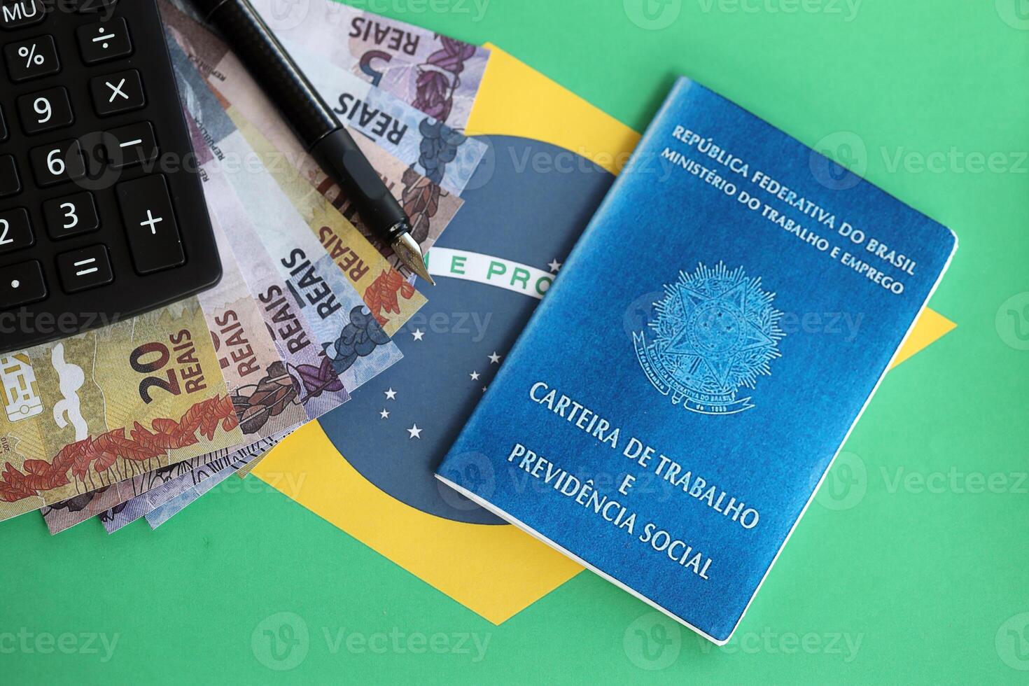 brasileño trabajo tarjeta y social seguridad azul libro y reales dinero cuentas con calculadora y bolígrafo en bandera de federativo república de Brasil foto