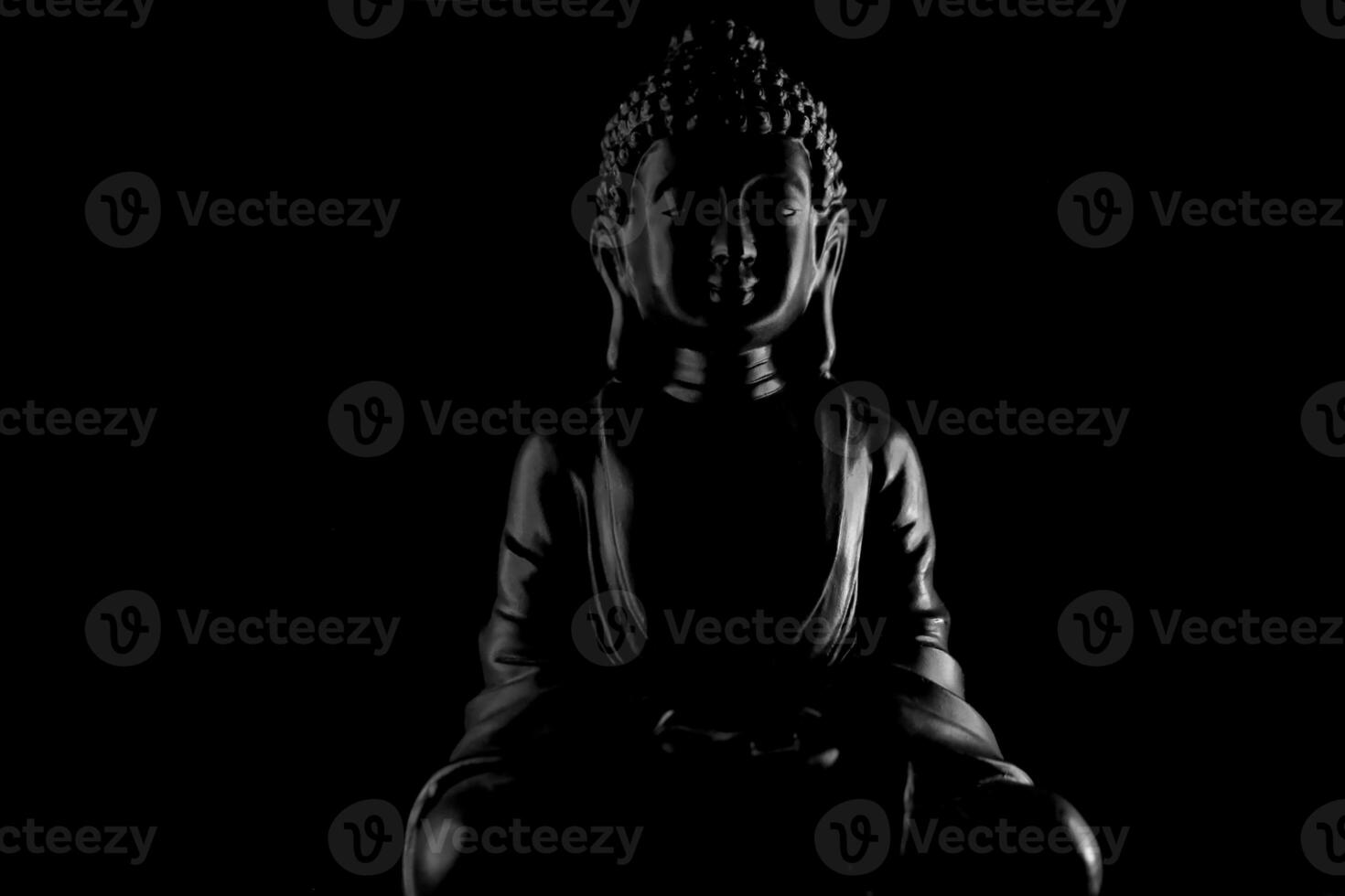 Buddha Purnima and Vesak day concept, Grey Buddha statue with low key light against deep black background photo