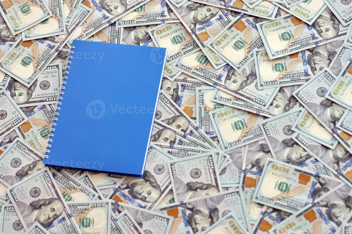 Office workplace table with blank notebook or notepad and many hundred dollar bills photo