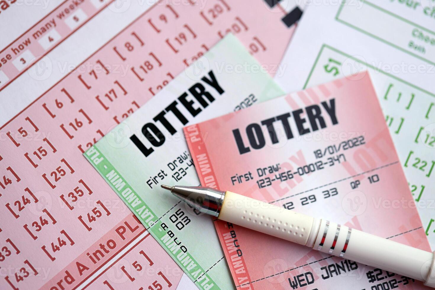 Green and red lottery tickets with pen on blank bills with numbers for playing lottery photo