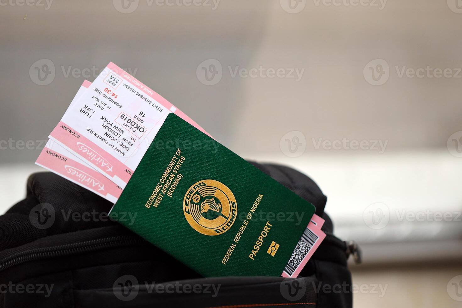 Green Nigerian passport with airline tickets on touristic backpack photo