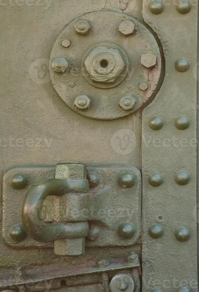 The texture of the wall of the tank, made of metal and reinforced with a multitude of bolts and rivets. Images of the covering of a combat vehicle from the Second World War photo