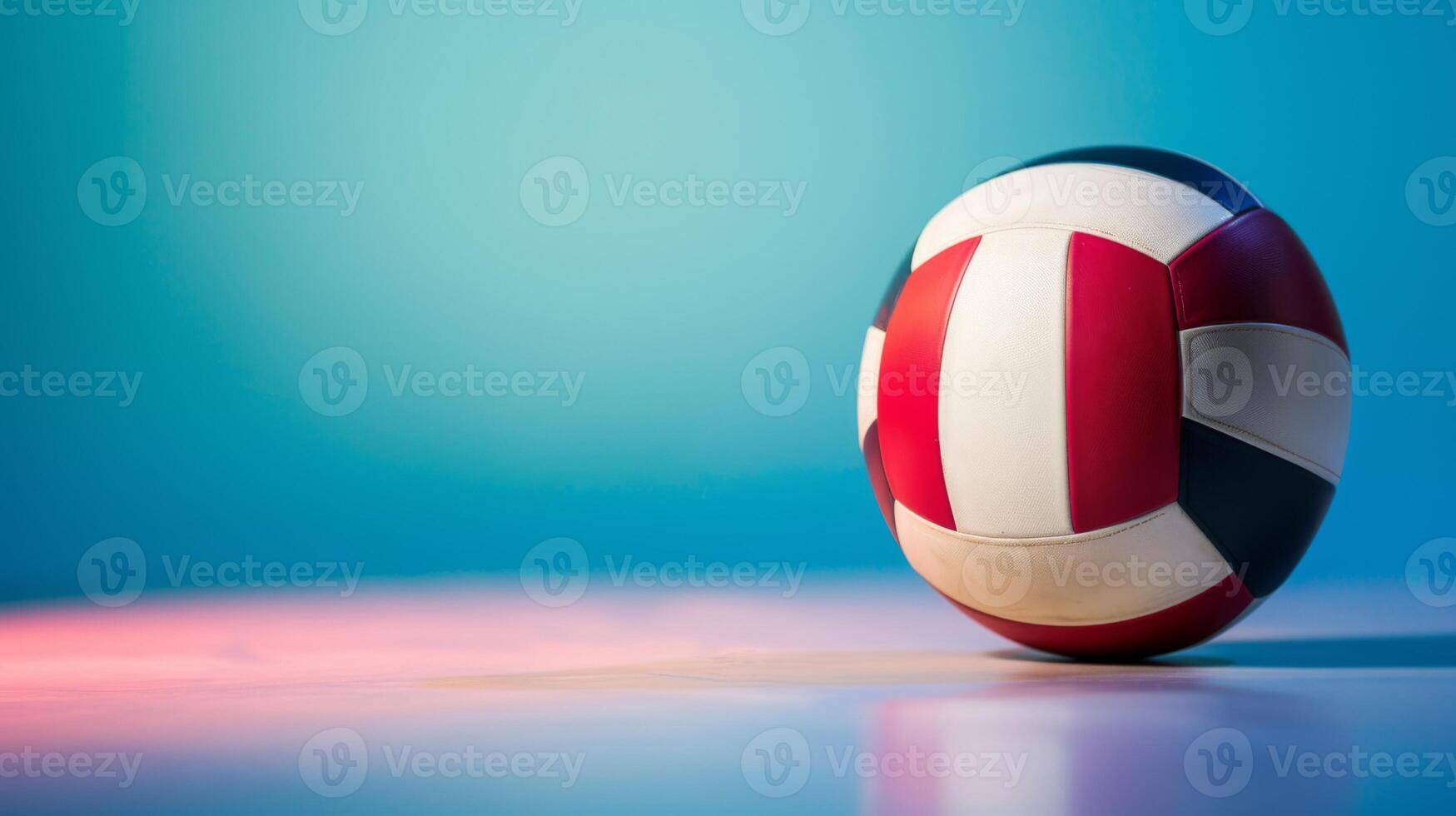 Volleyball sport equipment captured with dynamic red, white, blue colors and reflection on indoor court surface photo